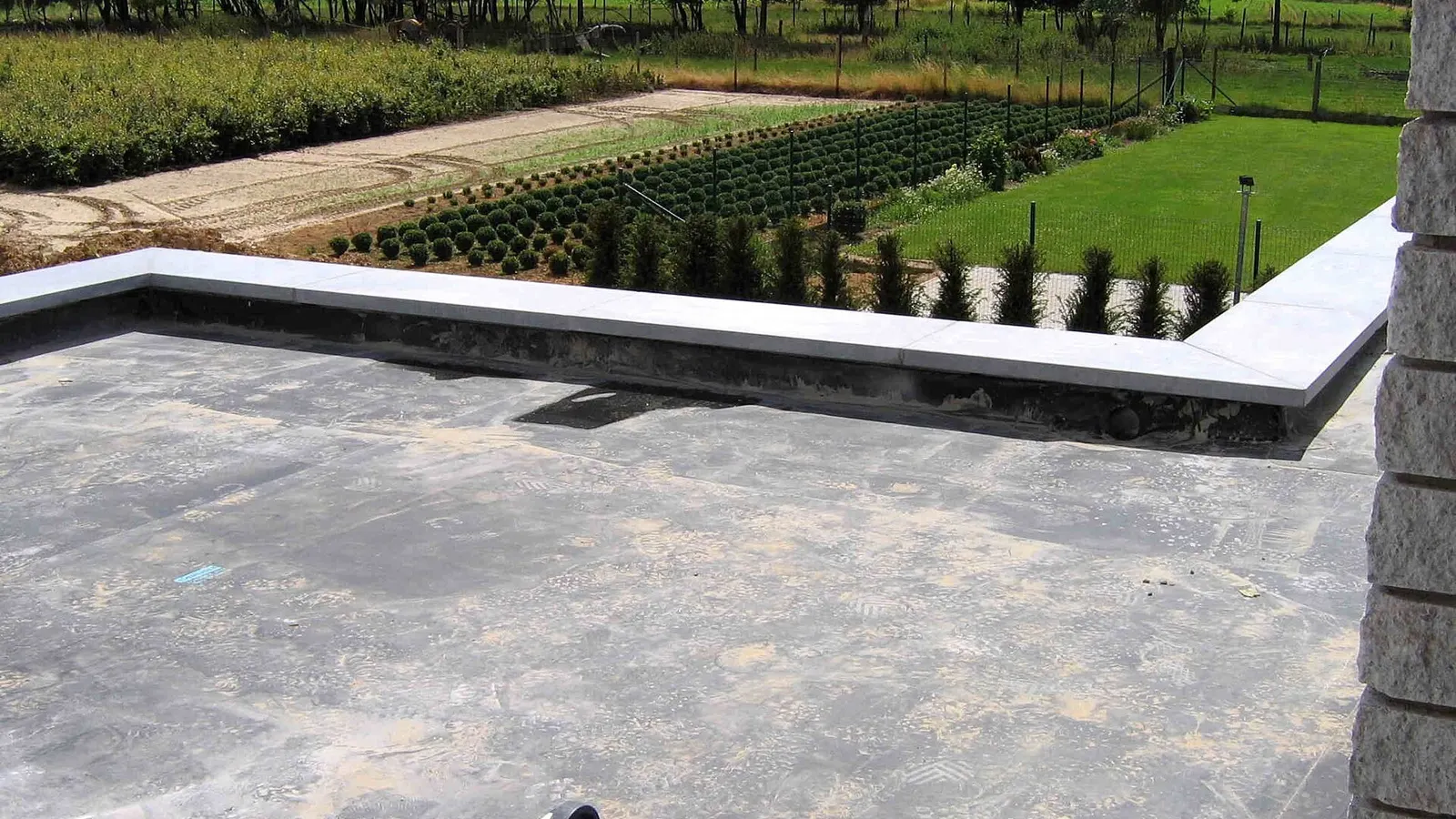 Completed EPDM rubber covered flat roof with neat upstand edges overlooking gardens