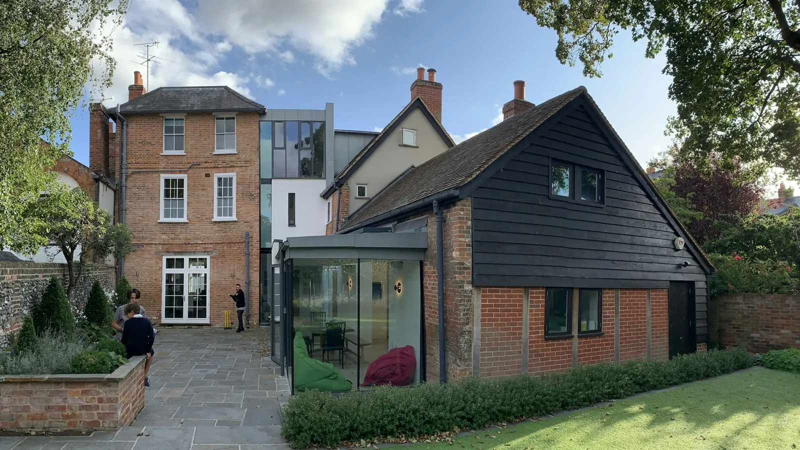 Modern timber-clad garden extension beside a red-brick English house
