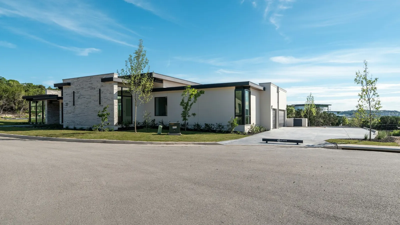 Modern single-storey homes with flat roofs under clear blue sky