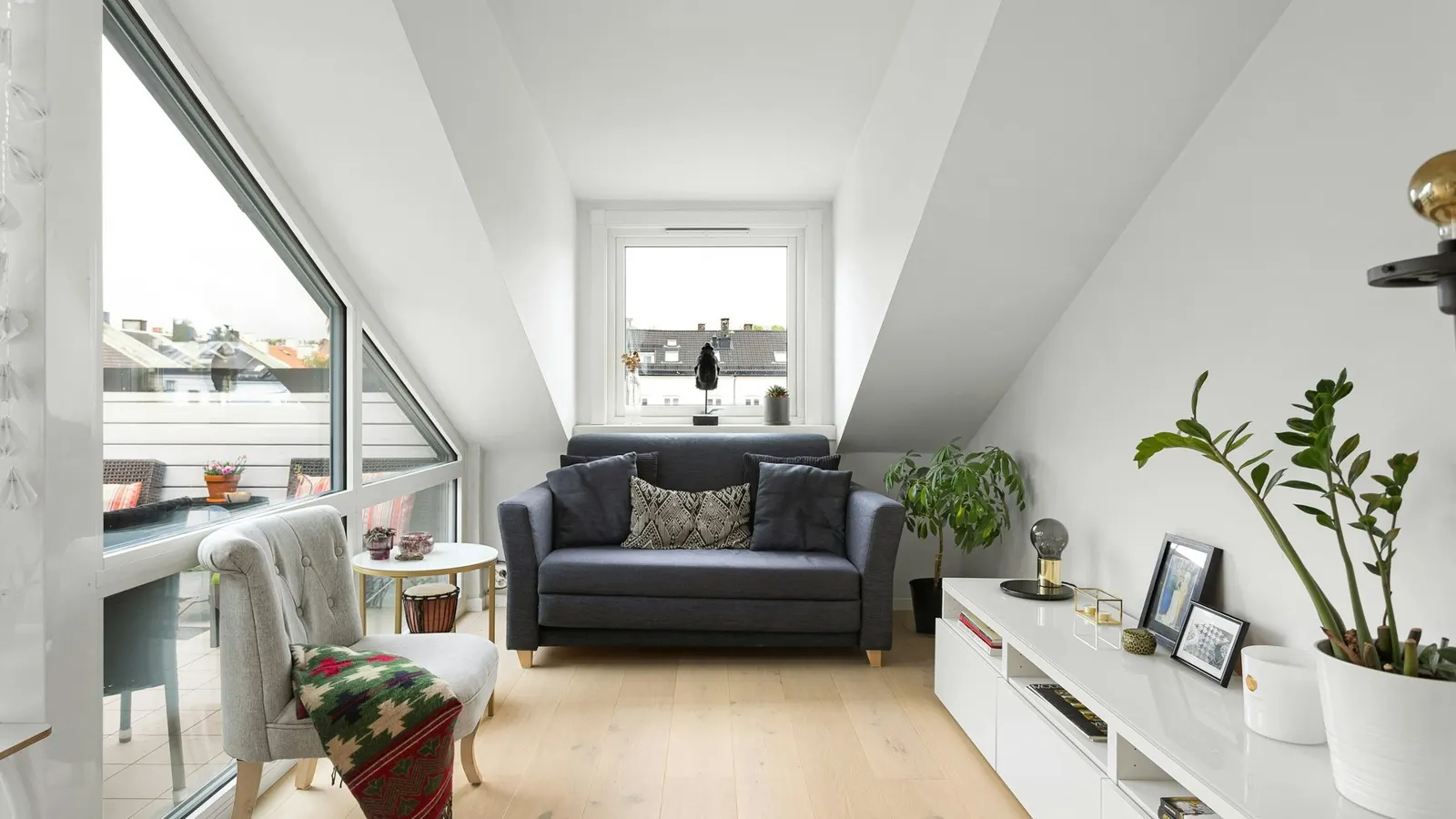 London loft conversion living space with glazed dormer and views over neighbouring rooftops