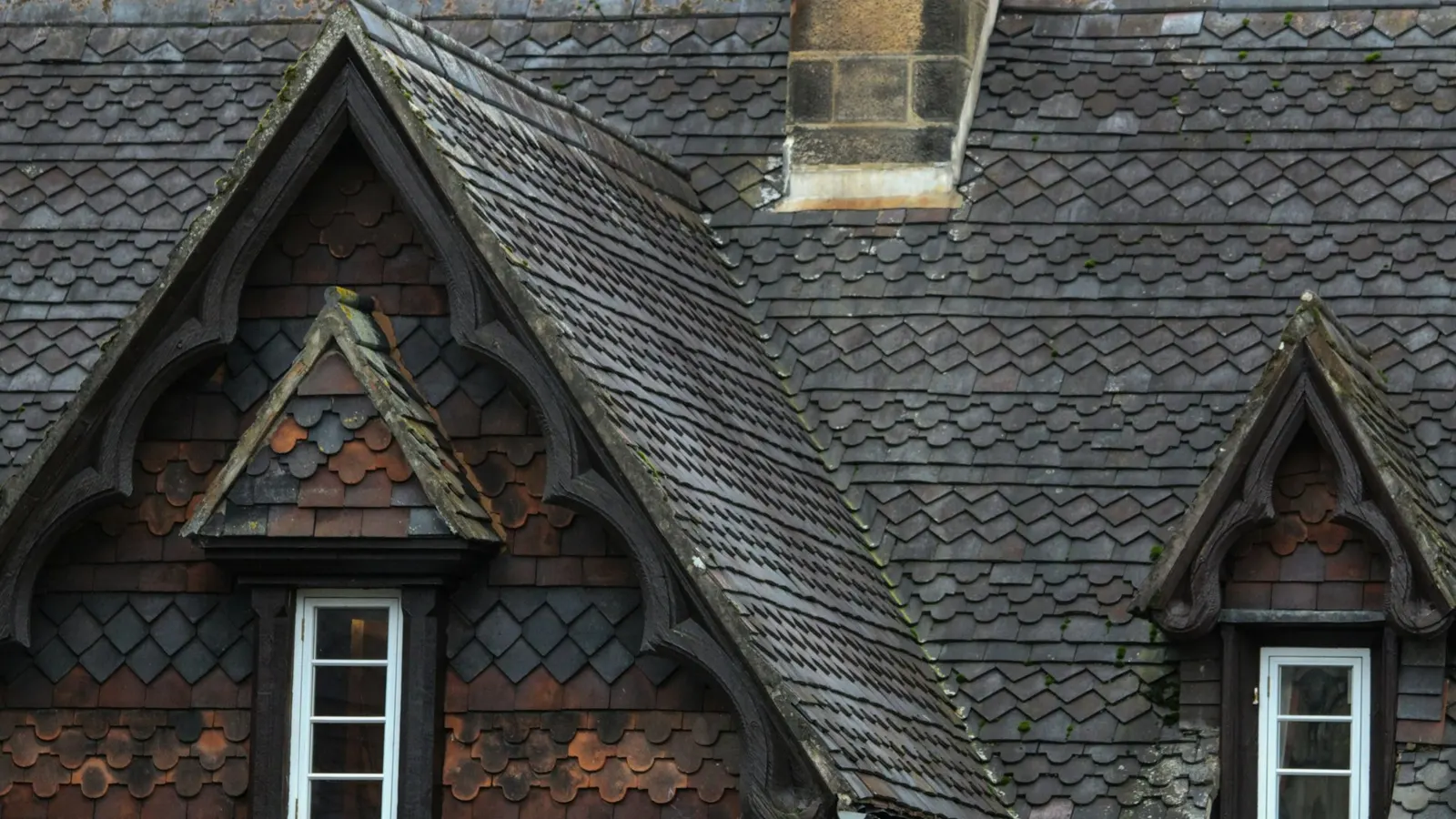 Finished slate roof with ornate gabled dormers and a chimney