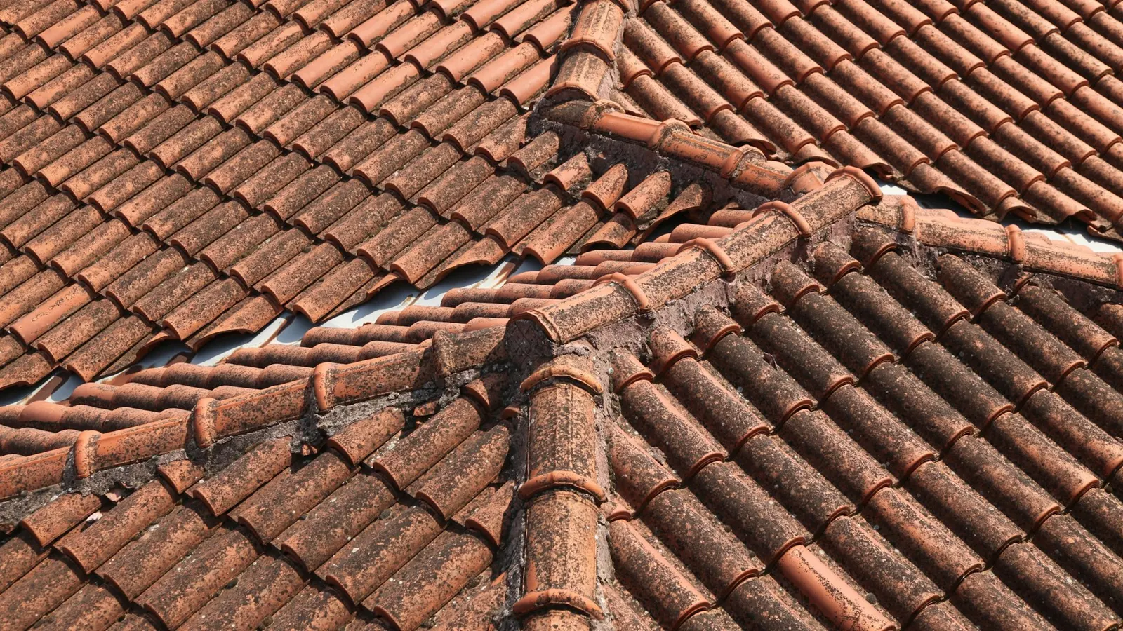 Close-up of weathered clay roof tiles with ridge and hip tiles