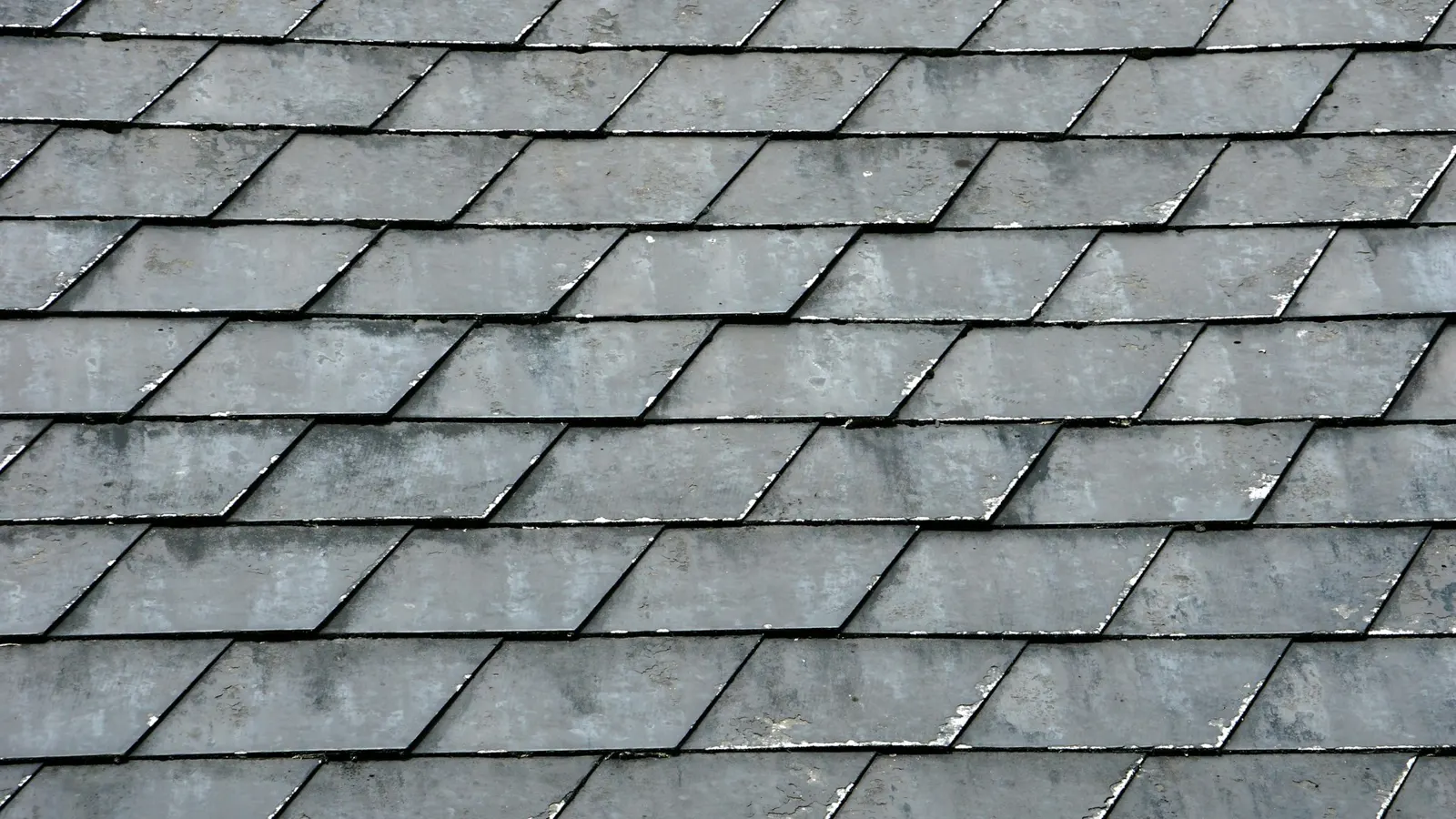 Close-up of natural grey slate roof tiles during a roof condition inspection