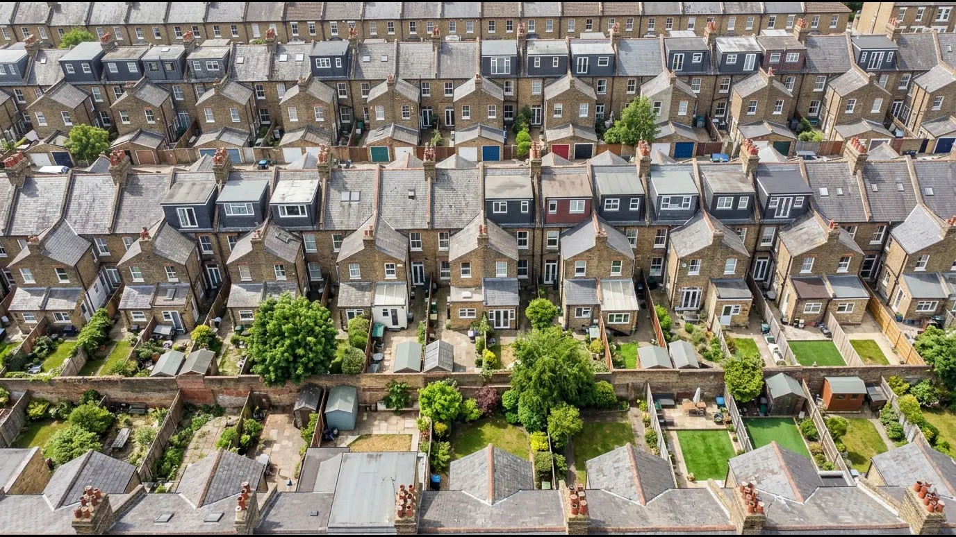 Aerial view over rows of London terraced houses with slate roofs, chimneys and rear dormers